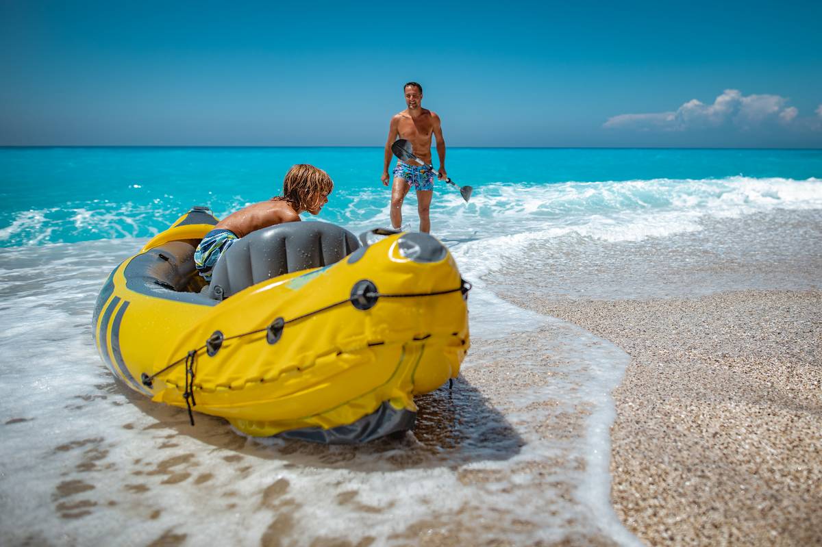 Father and son enjoy kayaking to the beach from their bug-out boat